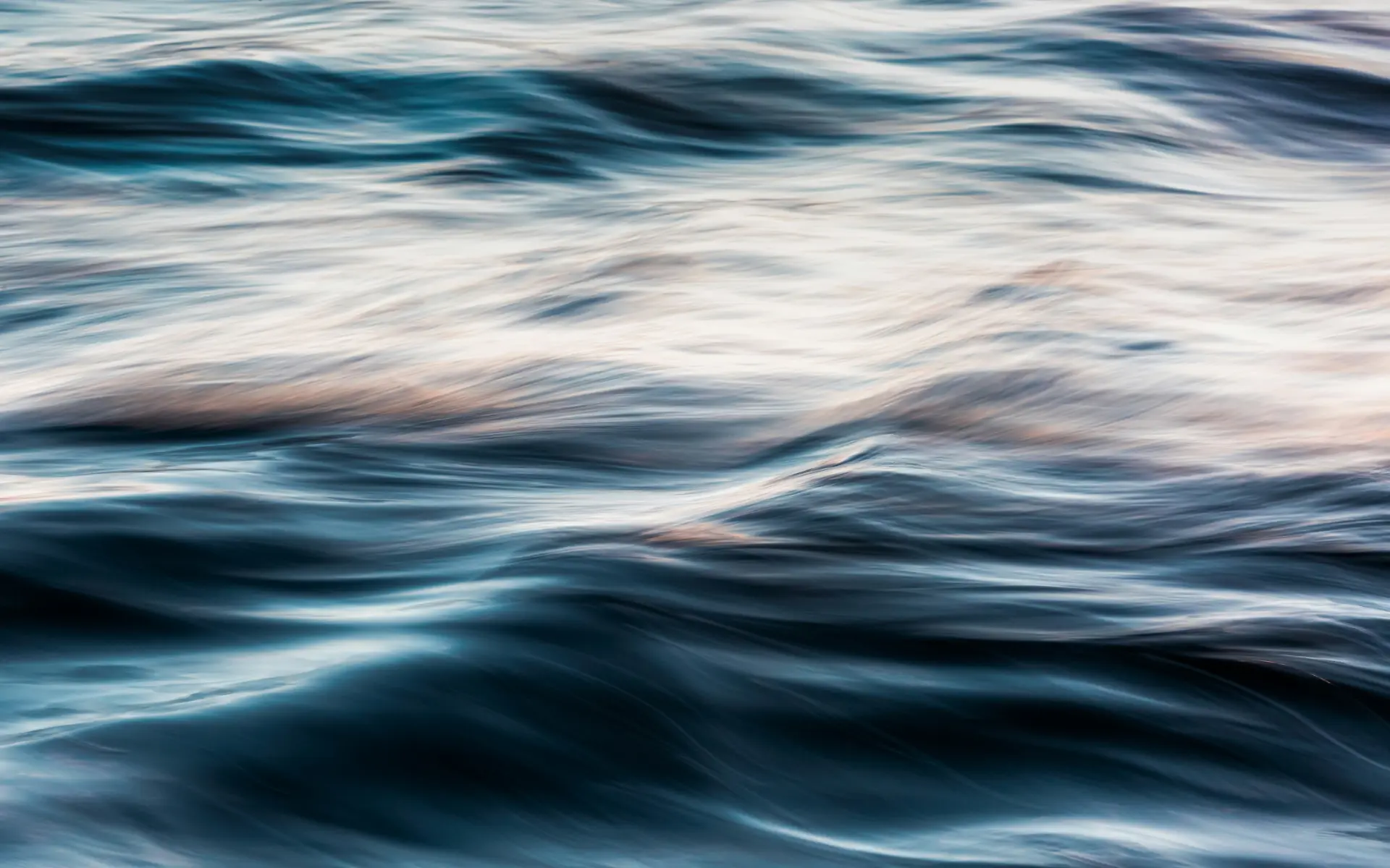 Surface de l'eau apaisée, vagues douces aux reflets bleutés